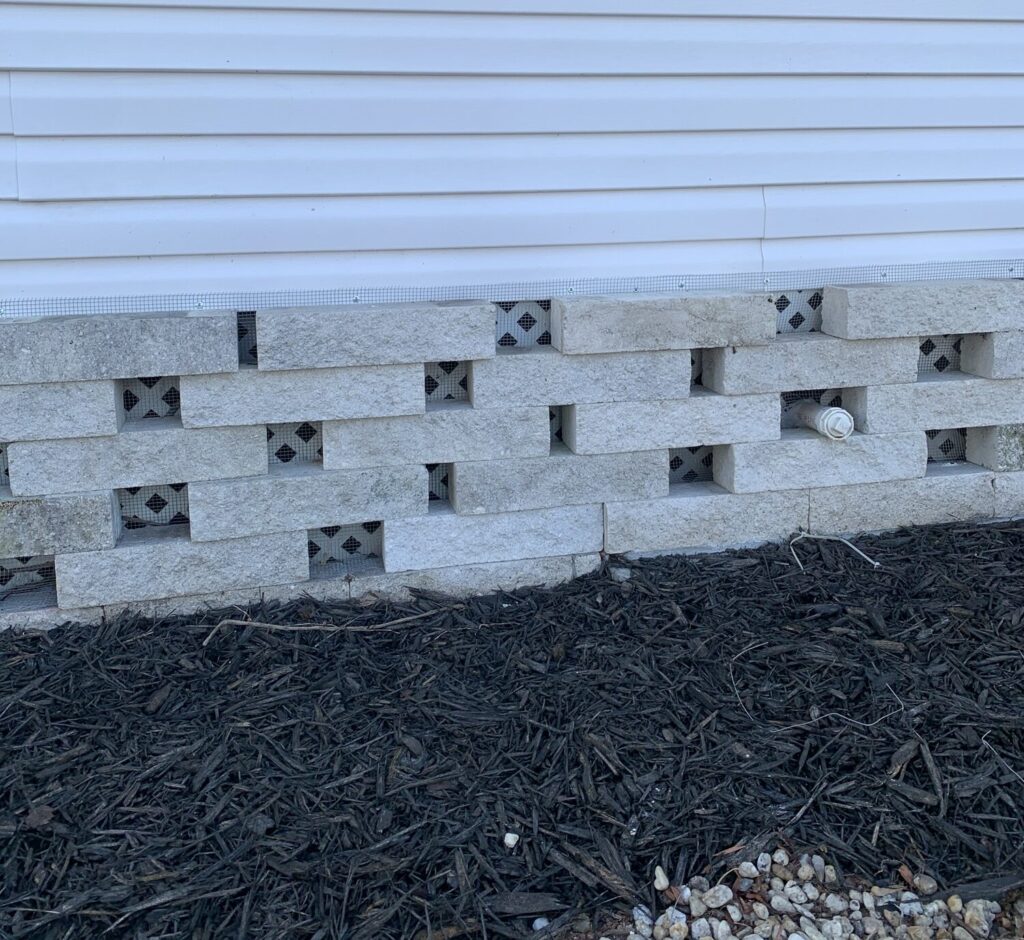 Mobile home in Holiday FL with hardware cloth barrier installed around the perimeter to prevent wildlife intrusion.

