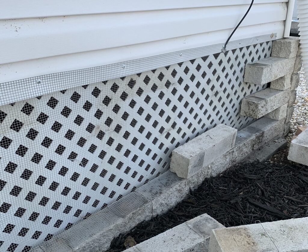 Completed wildlife exclusion beneath a Fish Hawk mobile home with professionally installed hardware cloth barriers