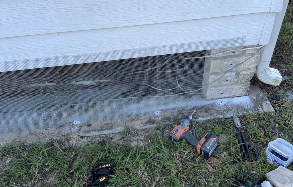 Gulfport mobile home secured with buried or tap‑conned hardware cloth barrier, plus sealed soffits, attic, and ground vents, and optional interior wrap.