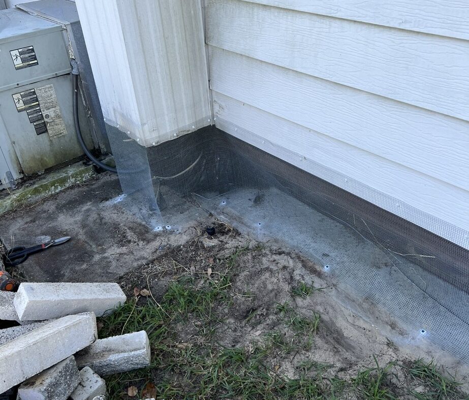 Aripeka mobile home with hardware cloth barrier tap‑conned to concrete foundation, sealed soffits and attic vents, and optional interior hardware cloth wrap.