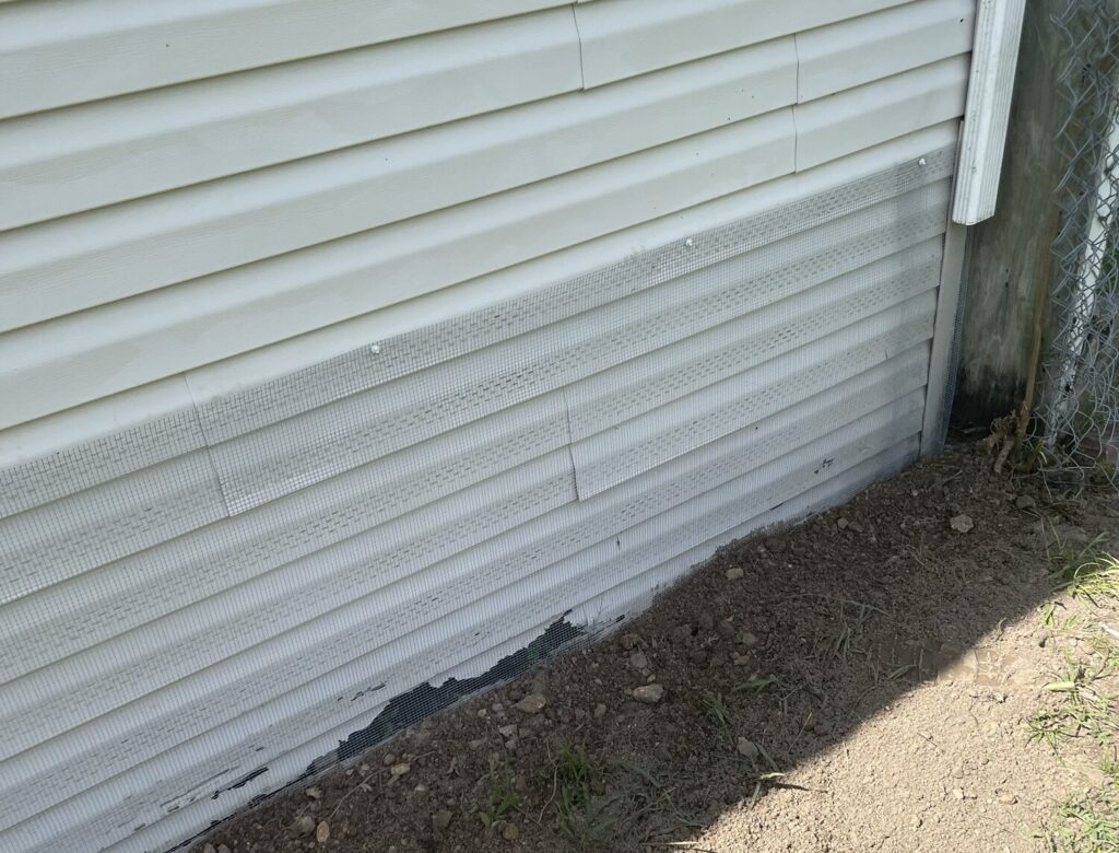 Meadow Oaks mobile home with hardware cloth barrier (buried or concrete‑mounted), sealed soffits/attic vents, and optional interior mesh wrap behind skirting.